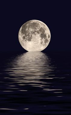 a full moon rising over the ocean at night with water reflecting it's surface