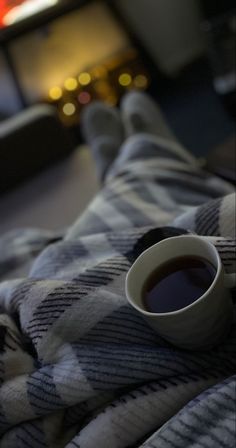 a cup of coffee sitting on top of a blanket