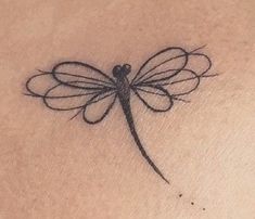 a small dragonfly tattoo on the chest