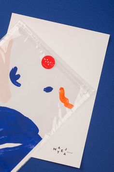 two envelopes with designs on them sitting next to each other in front of a blue background