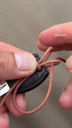 a person tying a shoelace on top of a small black piece of luggage in their hand