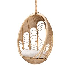 the hanging egg chair is made out of wicker and has white pillows on it