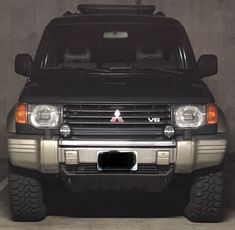 the front end of a black suv parked in a garage