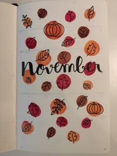 an open notebook with leaves and the word november written in black ink on top of it