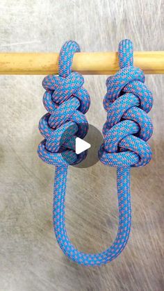 a blue and white rope hanging on top of a wooden pole next to a metal object