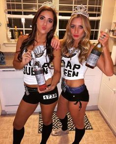 two beautiful young women standing next to each other holding bottles of beer in their hands