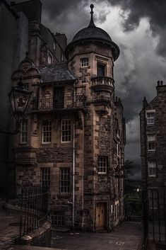 an old building with dark clouds in the background