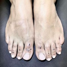 two feet with small tattoos on them