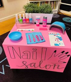 a pink table with nail salon items on it