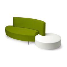 a green and white couch sitting on top of a white floor next to a round table