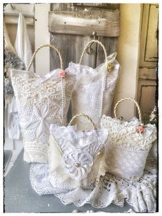 three white bags sitting next to each other on top of a table in front of an old wooden door