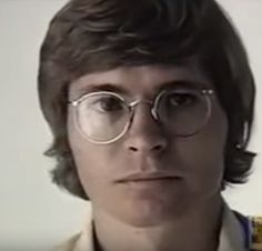 a man with glasses is looking at the camera