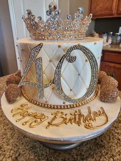 a birthday cake decorated with gold and white frosting