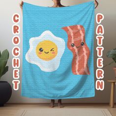 a woman holding up a blue towel with bacon and an egg on it that says cracker