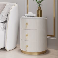 a white and gold nightstand next to a bed with a plant on top of it