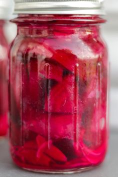 a jar filled with red liquid sitting on top of a table