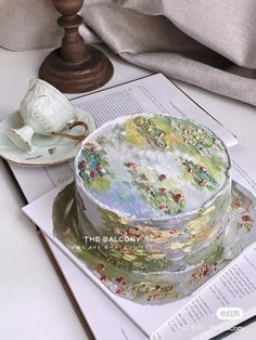 a cake sitting on top of a table next to a tea cup and saucer