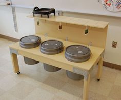 three trash cans sitting on top of a table