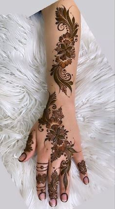 a woman's hand with henna tattoos on it