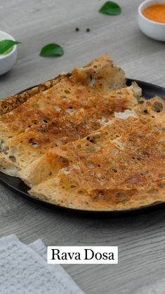 an omelet on a black plate with sauces and napkins around it