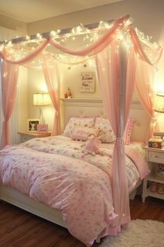 a bed with pink bedspread and lights on it