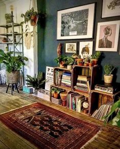 a living room filled with lots of plants and bookshelves on top of wooden floors