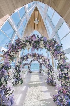 an outdoor ceremony setup with flowers and petals on the aisle leading to the beach side