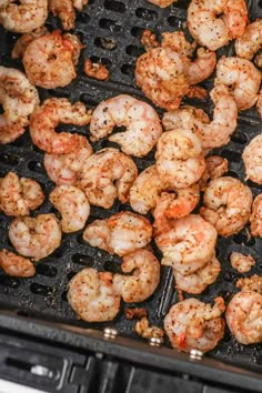 shrimp being cooked on the grill with tongs