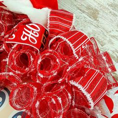 a pile of coca - cola cans sitting on top of a wooden floor next to a santa hat