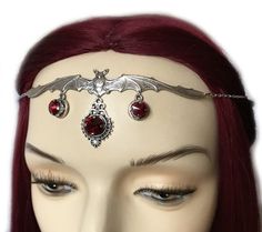 This gothic vampire inspired headpiece is made with a large antiqued silver plated bat and hanging pendants, accented with sparkling DARK RUBY RED glass rhinestones/jewels. Centerpiece is worn with silver plated cable chain. Decorated portion is 4 3/4" wide and 1 3/4" tall in the center.Headpiece is adjustable 21-24" with a lobster clasp and chain extender in the back. If you would like a different length or stone color, please send us a message. Vampire Headpiece, Gothic Crown Headpiece For Masquerade, Dark Red Metal Halo Crown, Gothic Crown Headpiece For Fantasy Events, Red Circlet Crown, Circlet Crown, Vampire Hair, Silver Headpiece, Tiara Headband