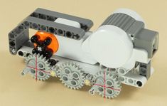 an orange and black toy train with gears on it