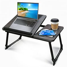 a laptop computer sitting on top of a wooden table next to a cup of coffee