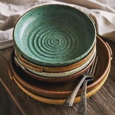 a stack of plates sitting on top of a wooden table