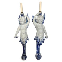 pair of blue and white angel candlesticks with candle holders in the shape of cherubs