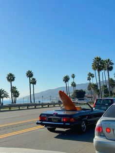 there is a surfboard sticking out of the back of a car's trunk