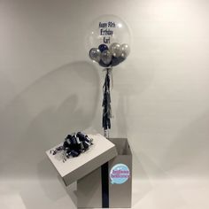 a present box with balloons and streamers in the shape of a birthday balloon on top