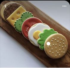 a wooden tray with cookies decorated like hamburgers