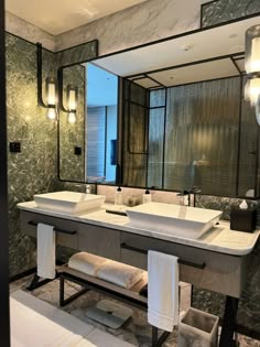 a large bathroom with two sinks and mirrors