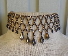 To bead this choker, I did netted weave using: twisted, bronze, bugle beads, brass and black, size 8 and 10, seed beads, and bronze, faceted, Czech glass, drop beads.   Because I added an extender, the length is adjustable; starting at 33 cm. (13"), up to 49.5 cm. (19 3/8").  It closes with a black, lobster claw clasp. If you would prefer the tail loop up rather than dangle, just let me know at time of purchase, and I can easily add a hook. at at the end. The last photo shows more of my work.   If you don't see the listing in my shop, contact me and, chances are, if I don't have it in stock I can probably make a custom necklace for you. This is a simple version of the amazing collars made by Native-Americans, for centuries, up to the present.  To see some examples, go to the National Museu Black Seed, Bugle Beads, Beaded Choker Necklace, Drop Beads, Beaded Choker, Custom Necklace, Choker Necklaces, A Hook, Czech Glass