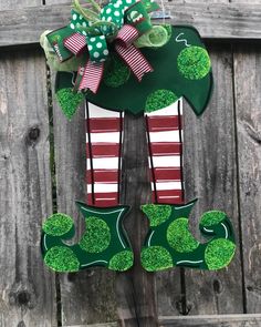 a green door hanger with red and white striped stockings, shamrocks and bows