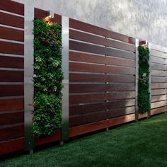 a fence with plants growing on it and some lights in the top right hand corner