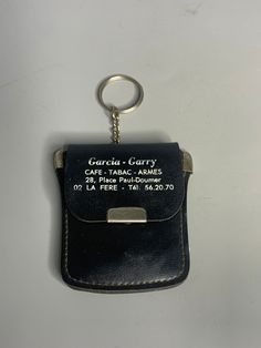 a black leather case with a metal keychain attached to it that says gerard carry