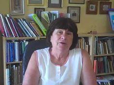 a woman sitting in front of a book shelf filled with books