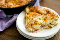 a white plate topped with a slice of lasagna next to a casserole dish