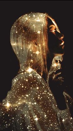 a woman's face is covered in sparkling lights