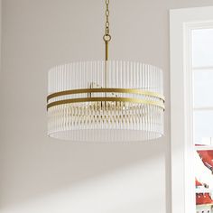 a chandelier hanging from the ceiling in a room with white walls and windows