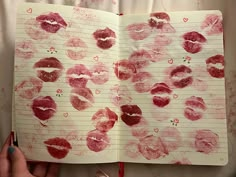 an open notebook with lots of red lipstick drawn on it and writing in the pages