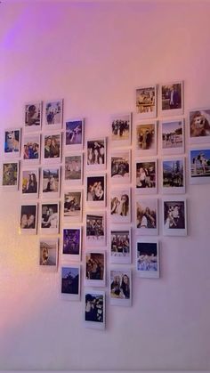 a bunch of pictures are hanging on the wall in front of a purple light,