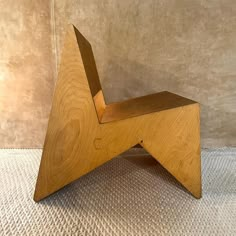 a wooden chair sitting on top of a white carpet next to a beige wall and floor