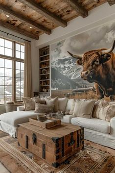 a living room filled with furniture and a cow painting on the wall above it's head